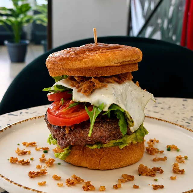 Hamburguesa con huevo frito, tomate y lechuga, de frente.