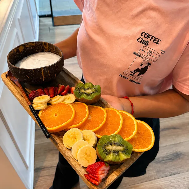 Tabla con yogur y fruta fresca: naranja, kiwi y fresas.